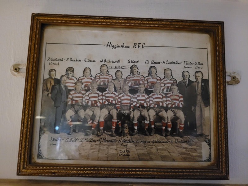 Framed Higginshaw R.F.C. team photo in red and white hoops, captained by H. Needham