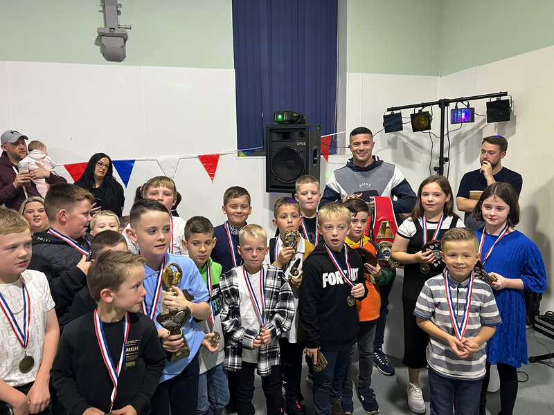 Children with medals and trophies at an awards night in the hall